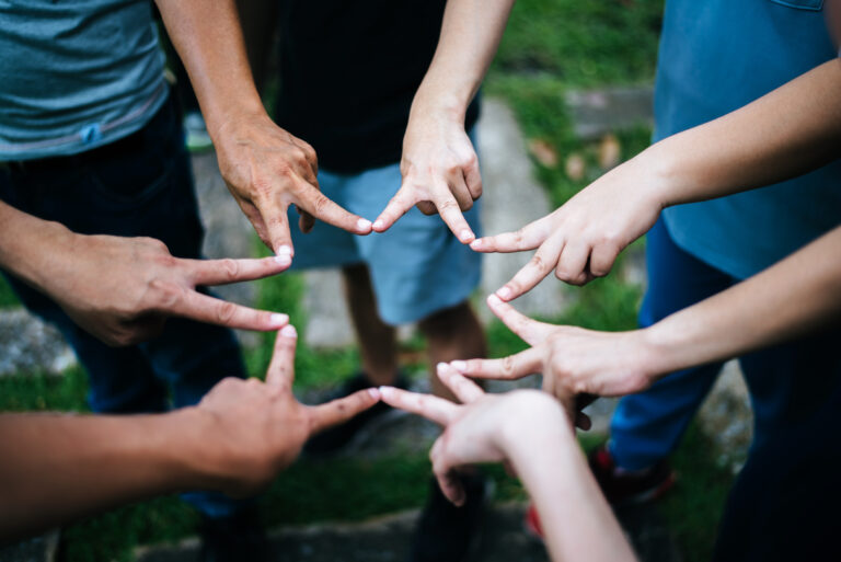 Women and men friends make star shape from fingers